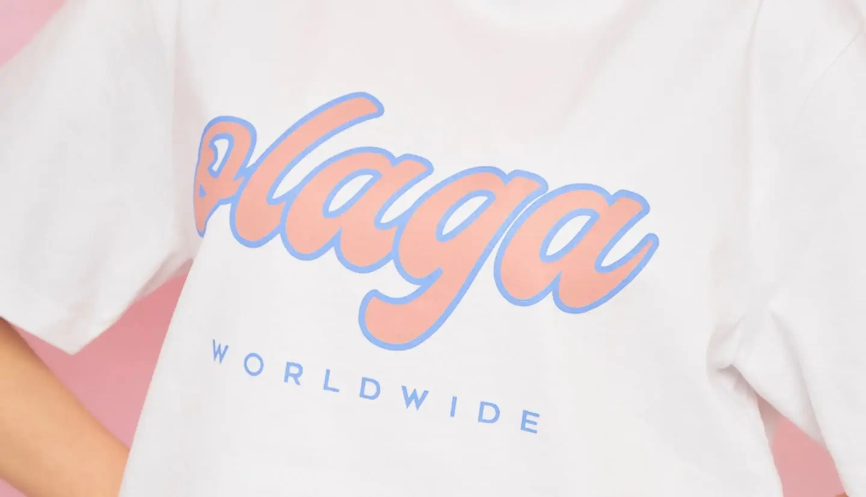A person wearing a white Olaga Studios T-shirt